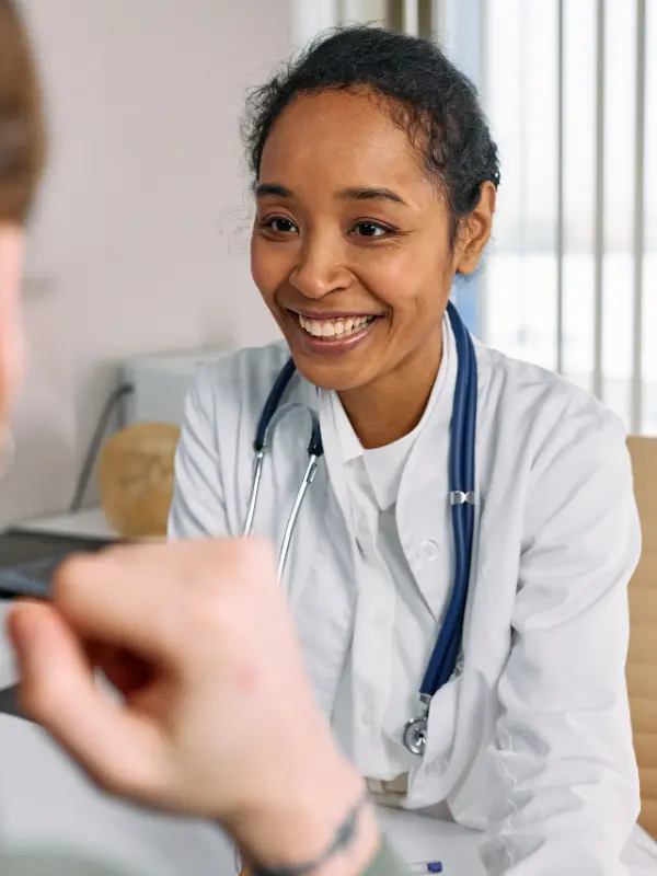 Smiling doctor providing personalized naturopathic care during a patient consultation.